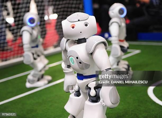 Visitors look at the football-playing robots at the world's biggest high-tech fair, the CeBIT on March 2, 2010 in the northern German city of...