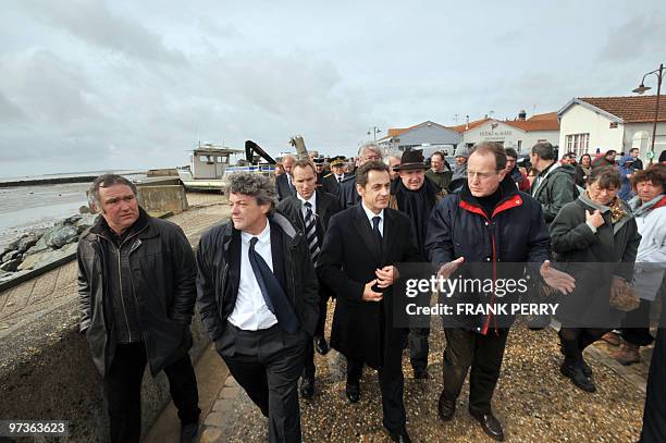 French President Nicolas Sarkozy flanked by Ecology Minister Jean-Louis Borloo visits Chatelaillon, a village damaged by Xynthia storm, western...