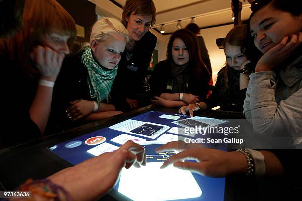 Children play a game on a touch-sensitive digital table at the Microsoft Digital Classroom at the CeBIT Technology Fair on March 2, 2010 in Hannover,...