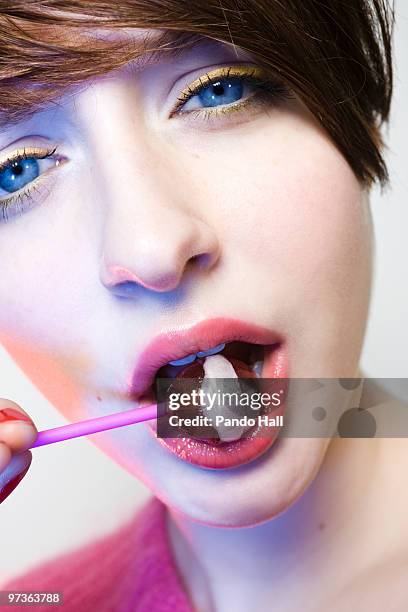 young woman biting into lollipop, close-up - wonky fringe stock pictures, royalty-free photos & images