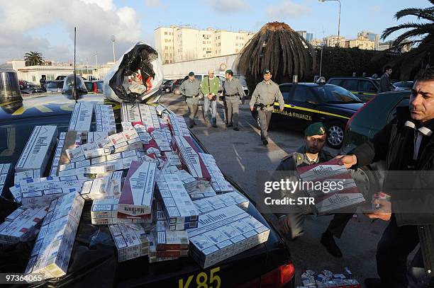 Italian Guardia di Finanza policemen display seized cigarettes following an operation targetting the illegal sale of cigarettes in Naples on March 2,...