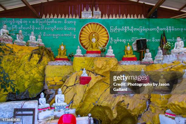 buddha statues outside a small cave in loikaw, myanmar - loikaw fotografías e imágenes de stock