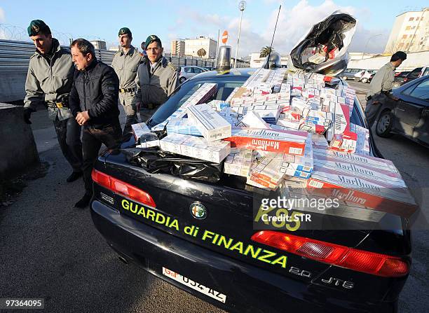 Italian Guardia di Finanza policemen arrest a man during a operation targetting the illegal sale of cigarettes in Naples on March 2, 2010. The...