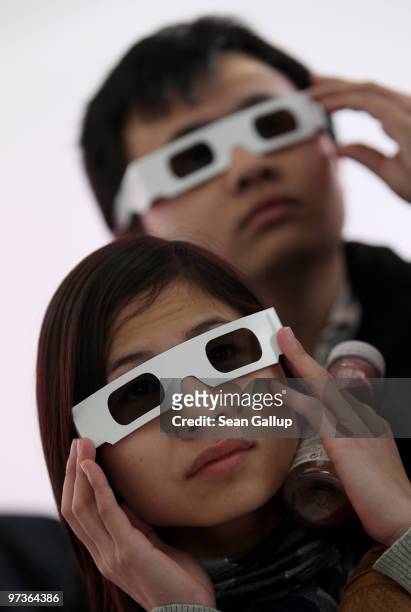 Visitors watch a 3D presentation at the Deutsche Telekom stand at the CeBIT Technology Fair on March 2, 2010 in Hannover, Germany. CeBIT will be open...