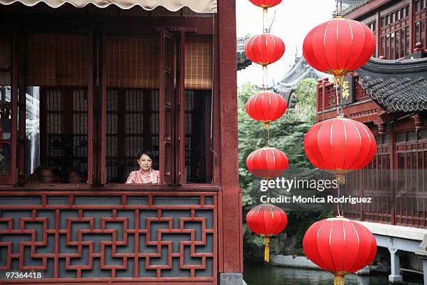 young female at window of  a floating tea house - woman red lantern stock pictures, royalty-free photos & images