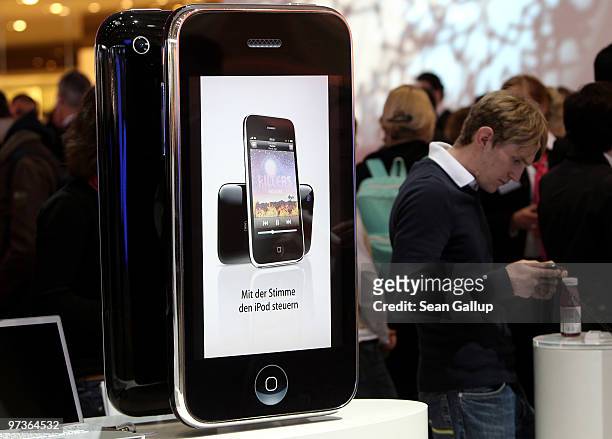 Visitors look at Apple iPhones at the Deutsche Telekom stand at the CeBIT Technology Fair on March 2, 2010 in Hannover, Germany. CeBIT will be open...