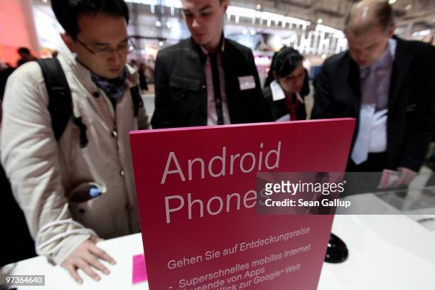 Visitors look at mobile phones using the Android operating system at the Deutsche Telekom stand at the CeBIT Technology Fair on March 2, 2010 in...