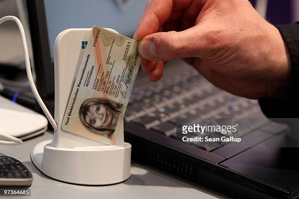 Host displays a sample new German national identity card and a coupled data scanner at the Fraunhofer Institute stand at the CeBIT Technology Fair on...