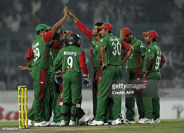 Bangladeshi cricketers celebrate the dismissal of England cricketer Kevin Pietersen during the second One Day International match between Bangladesh...