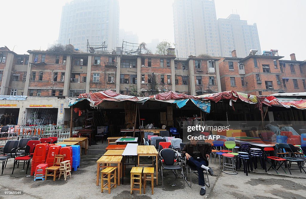 A Chinese man rests at his stall at a po