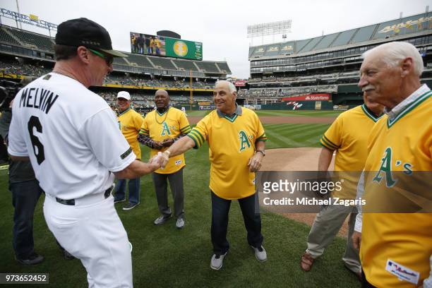 Manager Bob Melvin of the Oakland Athletics shakes hands with Sal Bando on the field prior to the game against the Arizona Diamondbacks at the...