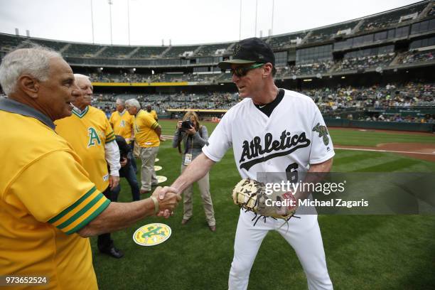 Manager Bob Melvin of the Oakland Athletics shakes hands with Sal Bando on the field prior to the game against the Arizona Diamondbacks at the...