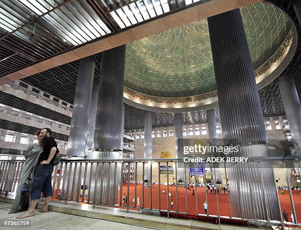 Tourists have their photographs taken inside the Istiqlal mosque in Jakarta on February 26, 2010. The Istiqlal mosque - named after the Arabic word...