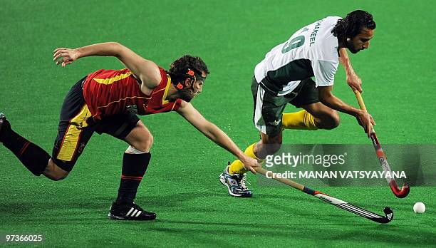 Spanish hockey player Sergi Enrique vies for the ball with Pakistani hockey player Shakeel Abbasi during their World Cup 2010 match at the Major...