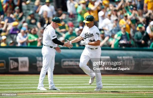 Matt Olson of the Oakland Athletics is congratulated by Third Base Coach Matt Williams while running the bases after hitting a home run during the...