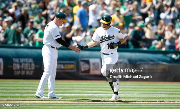 Chad Pinder of the Oakland Athletics is congratulated by Third Base Coach Matt Williams while running the bases after hitting a home run during the...