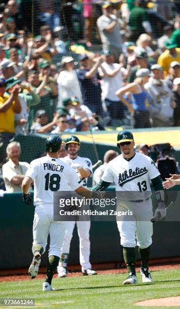Chad Pinder of the Oakland Athletics is congratulated by Bruce Maxwell after hitting a home run during the game against the Arizona Diamondbacks at...