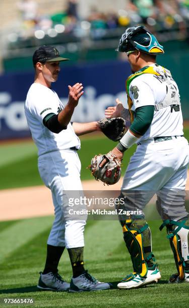 Daniel Mengden and Bruce Maxwell of the Oakland Athletics celebrate on the field following the game against the Arizona Diamondbacks at the Oakland...