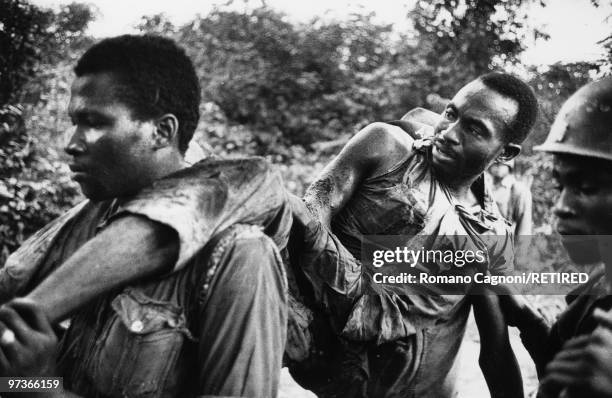 Nigeria civil war, Biafra, wounded soldier carried by comrades in arms.