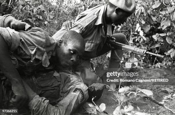 Africa, Nigeria civil war, Biafra, under fire, soldiers hauling away a wounded soldier.