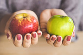 woman hand holding red and green apple fruit for dieting concept background