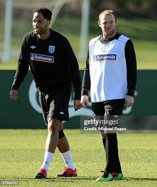 Joleon Lescott warms up alongside Wayne Rooney during an England training session at London Colney on March 2, 2010 in St Albans, England.