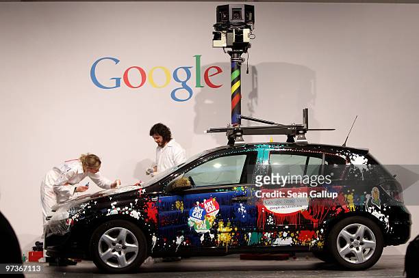 Artists paint a German Google Street View car at the Google stand at the CeBIT Technology Fair on March 2, 2010 in Hannover, Germany. Google's Street...
