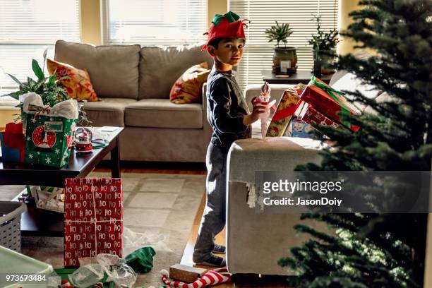 young boy christmas morning decorating christmas tree - jasondoiy stock pictures, royalty-free photos & images