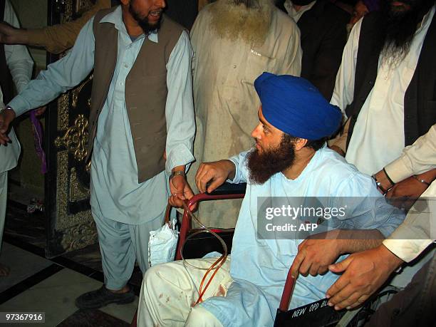 Injured freed Pakistani Sikh, Sirjeeth Singh sits on a wheelchair as he arrives for a talk with media representatives in Peshawar on March 2, 2010....
