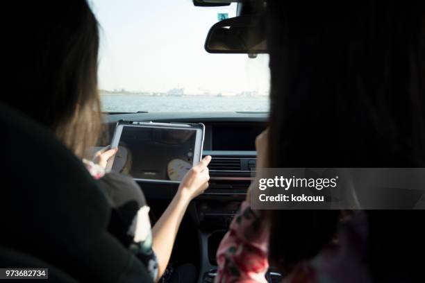 two woman in the car - girl in car with ipad stock pictures, royalty-free photos & images