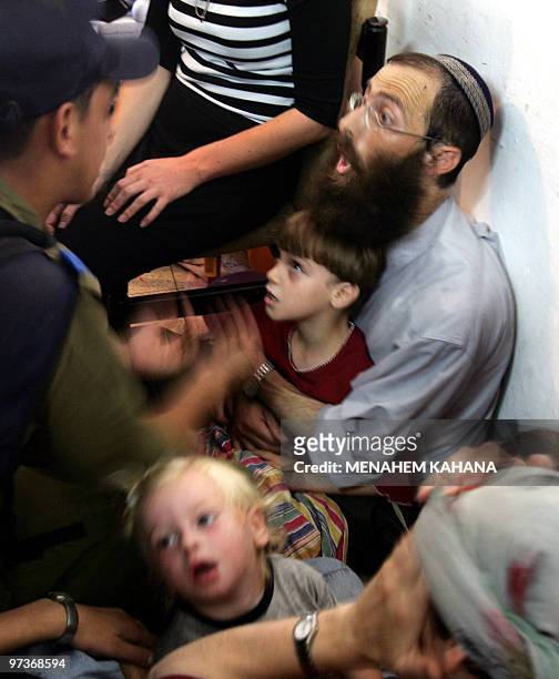 Yaacov Haeitan argues with Israeli soldiers as he refuse to be evacuated with his family from his home, 18 August 2005 in the Gaza Strip settlement...