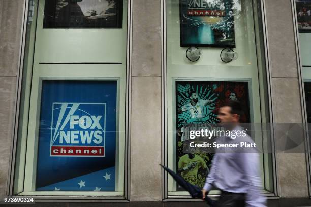 People walk by the headquarters of 21st Century Fox on June 13, 2018 in New York City. Comcast, the giant cable operator, on Wednesday officially...