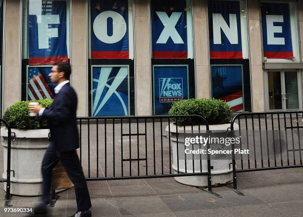 Man walks by the headquarters of 21st Century Fox on June 13, 2018 in New York City. Comcast, the giant cable operator, on Wednesday officially made...