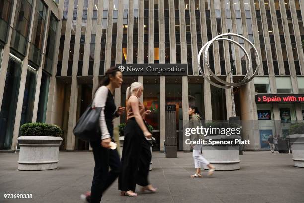 People walk by the headquarters of 21st Century Fox on June 13, 2018 in New York City. Comcast, the giant cable operator, on Wednesday officially...