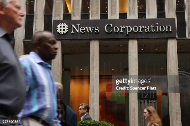 People walk by the headquarters of 21st Century Fox on June 13, 2018 in New York City. Comcast, the giant cable operator, on Wednesday officially...