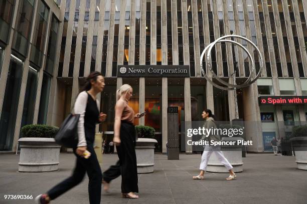 People walk by the headquarters of 21st Century Fox on June 13, 2018 in New York City. Comcast, the giant cable operator, on Wednesday officially...