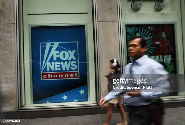 People walk by the headquarters of 21st Century Fox on June 13, 2018 in New York City. Comcast, the giant cable operator, on Wednesday officially...