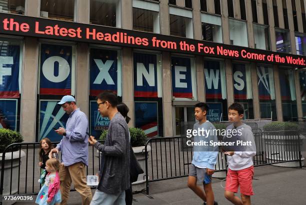 People walk by the headquarters of 21st Century Fox on June 13, 2018 in New York City. Comcast, the giant cable operator, on Wednesday officially...