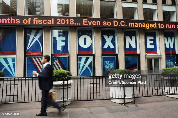 People walk by the headquarters of 21st Century Fox on June 13, 2018 in New York City. Comcast, the giant cable operator, on Wednesday officially...