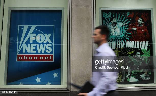 Man walks by the headquarters of 21st Century Fox on June 13, 2018 in New York City. Comcast, the giant cable operator, on Wednesday officially made...