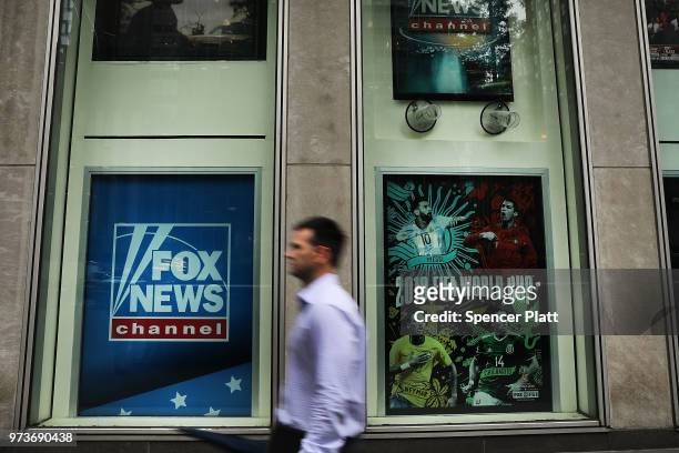Man walks by the headquarters of 21st Century Fox on June 13, 2018 in New York City. Comcast, the giant cable operator, on Wednesday officially made...
