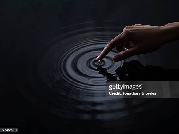 finger creating ripples - rippled stock pictures, royalty-free photos & images