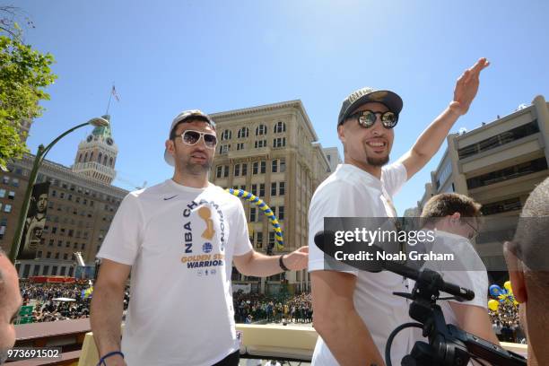 Zaza Pachulia and Klay Thompson of the Golden State Warriors interact with fans during the Golden State Warriors Victory Parade on June 12, 2018 in...