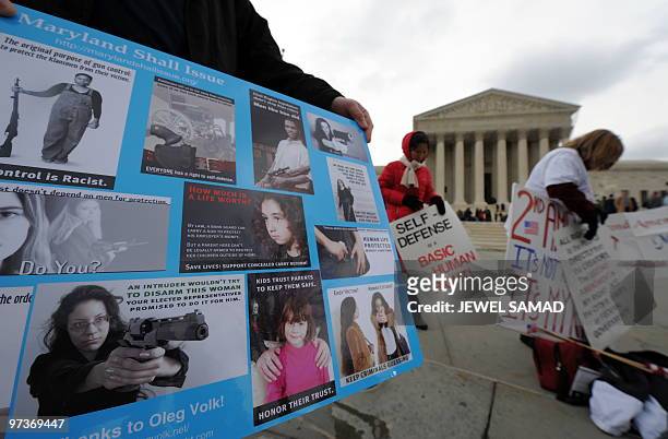 Demonstrators display placards supporting a case on bearing arms in front of the Supreme Court in Washington, DC, on March 2, 2010. State and local...