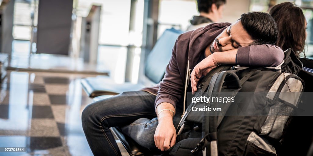 Backpacker napping while waiting for the airplane