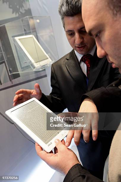 Visitor examines the DR-900 9" Touch E-Reader at the Asus stand at the CeBIT Technology Fair on March 2, 2010 in Hannover, Germany. CeBIT will be...