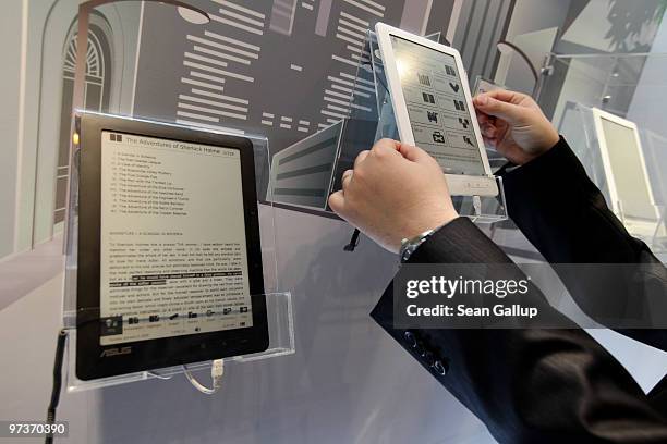 Visitor examines the DR-900 9" Touch E-Reader at the Asus stand at the CeBIT Technology Fair on March 2, 2010 in Hannover, Germany. CeBIT will be...