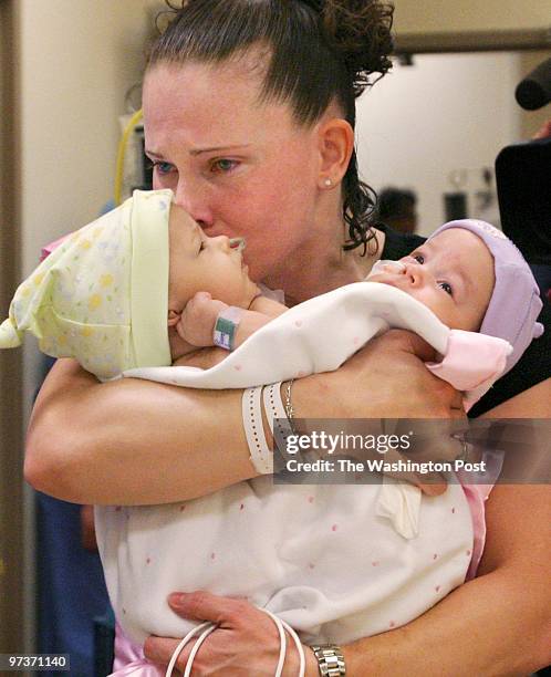 Melissa Buckles weeps as she prepares to hand off Jade and Erin Buckles for their successful surgery at Children's Hospital separating the conjoined...