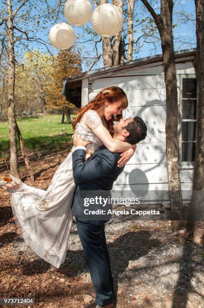 groom lifting bride during first dance - rustic wedding stock pictures, royalty-free photos & images