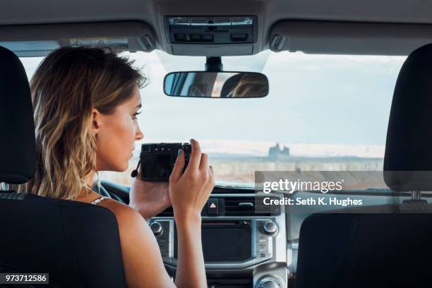 young woman sitting in vehicle, taking photo through windscreen, using camera, mexican hat, utah, usa - mexican hat fotografías e imágenes de stock